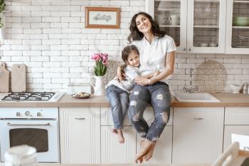 Happy mother with daughter in kitchen at home�