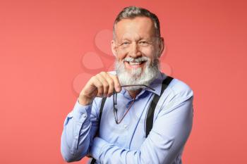 Portrait of handsome senior man on color background�