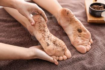 Young woman undergoing treatment with body scrub in spa salon�