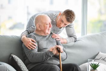 Male caregiver with senior man in nursing home�
