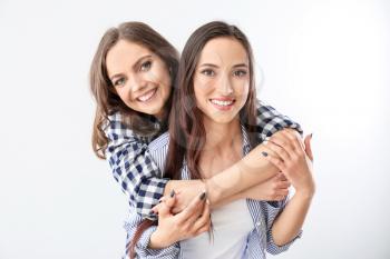 Portrait of happy lesbian couple on white background�