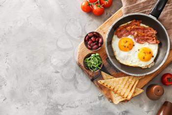 Traditional English breakfast with fried eggs, bacon, beans and toasts on table�