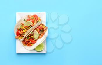 Plate with tasty tacos on color background�