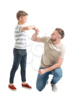 Portrait of happy father and son bumping fists on white background�