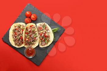 Slate plate with tasty fresh tacos on color background�