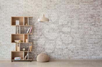Interior of modern room with bookcase, pouf and lamp�