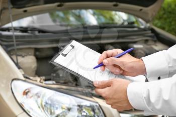 Insurance agent near damaged car outdoors, closeup�