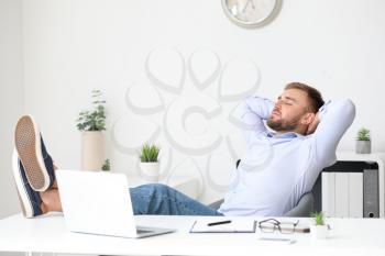 Handsome young man relaxing at workplace�