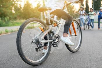 Cute children riding bicycles outdoors�