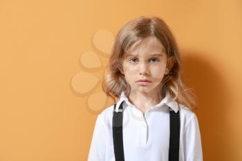 Sad little girl on color background�