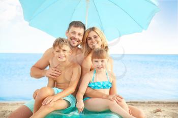 Portrait of happy family on sea beach�