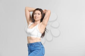 Young body positive woman on grey background�