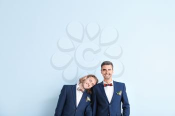 Portrait of happy gay couple on their wedding day against color background�
