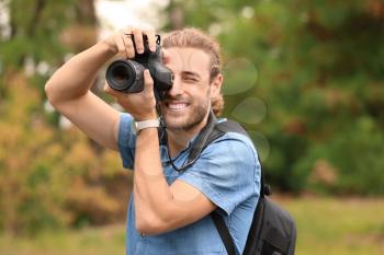 Young male photographer with camera outdoors�