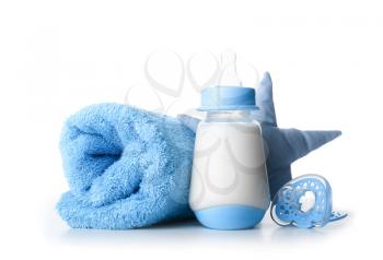 Bottle of milk for baby with pacifier, towel and toy on white background�
