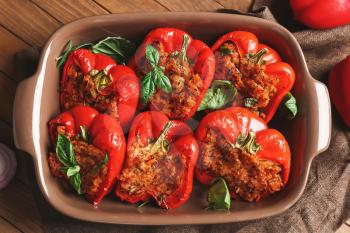 Baking dish with tasty stuffed pepper on table�