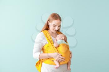 Mother with cute baby on color background�