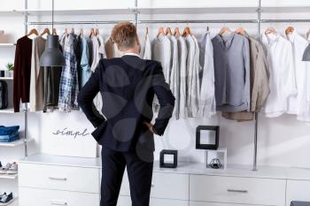 Handsome man choosing clothes in dressing room�