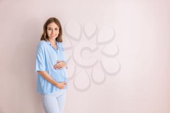 Beautiful pregnant woman on light background�