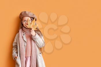 Fashionable little girl in autumn clothes on color background�