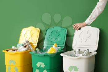 Woman throwing garbage into container. Recycling concept�