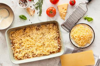 Cooking of tasty lasagna on white background�