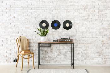 Record player with vinyl disc on table in interior of room�