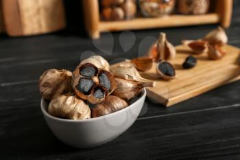 Bowl with black garlic on kitchen table�