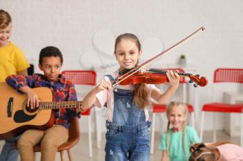 Cute little girl playing violin at music school�