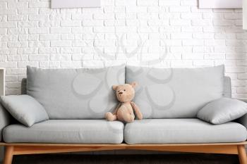 Cute baby toy on sofa in room�