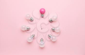 Creative clock made of light bulbs on color background�