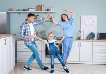 Happy family dancing in kitchen�
