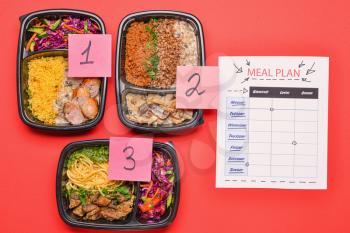Containers with healthy food and meal plan on color background�
