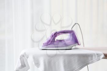 Electric iron and clothes on board at home�