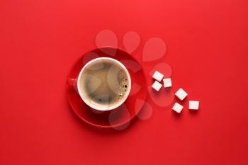Cup of hot coffee and sugar on color background�