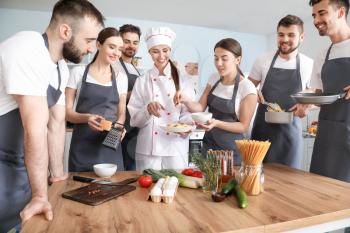 Female chef and group of young people during cooking classes�
