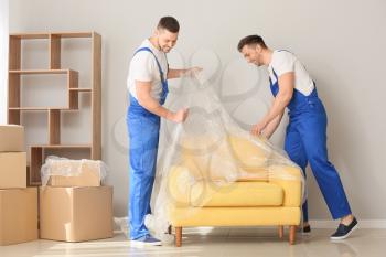 Loaders covering furniture with polyethylene film before carrying�