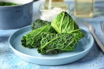 Plate with stuffed cabbage leaves on table�