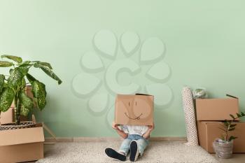 Kid with moving box having fun in new flat�
