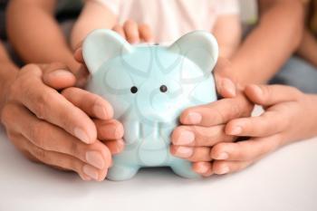 Family with piggy bank at table�