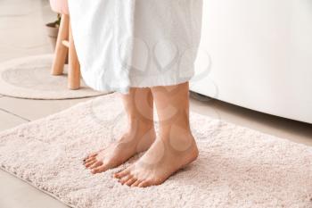 Woman standing on soft rug after bathing�