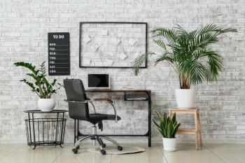 Stylish workplace with modern laptop and houseplant in room�