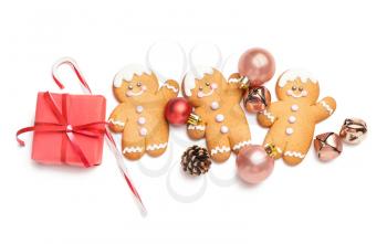 Tasty gingerbread cookies and Christmas decor on white background�