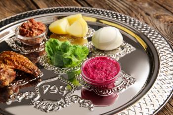 Passover Seder plate with traditional food on table, closeup�