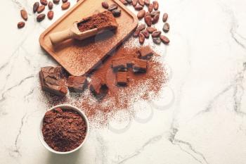 Beans, chocolate and cocoa powder on light background�