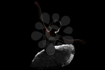 Silhouette of beautiful young ballerina on dark background�
