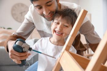 Father and little son fixing chair at home�