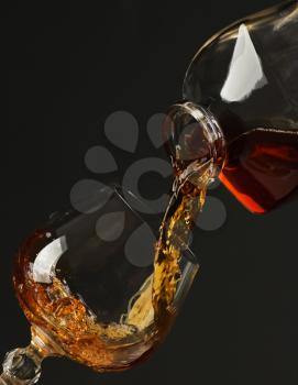 Brandy being poured from old bottle to glass