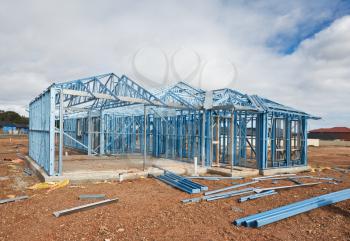 New home under construction using steel frames against cloudy sky