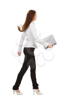  young businesswoman walking with laptop, isolated on white background